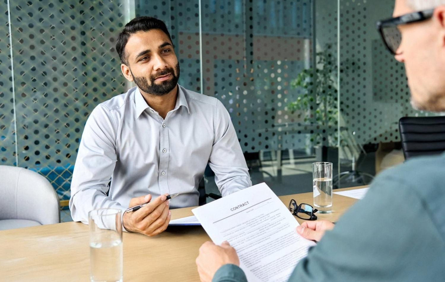 Businessman in a Dubai meeting room discussing a contract before signing it